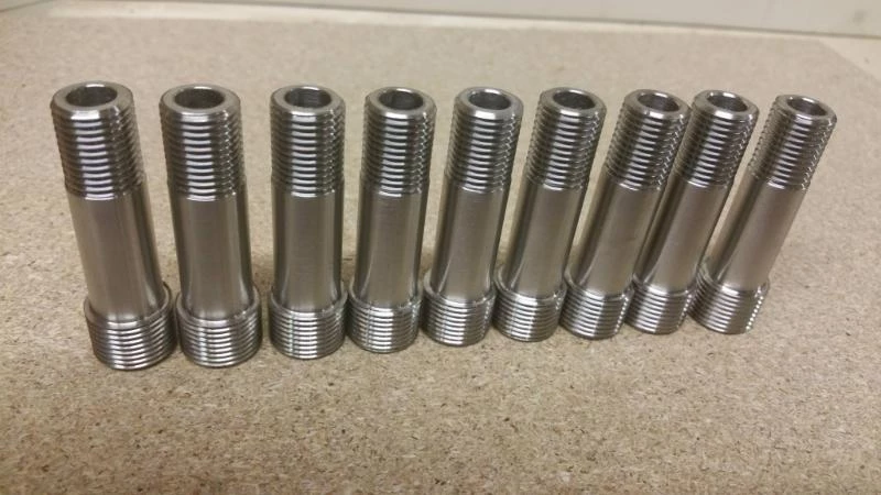 Série de goujons filetés en inox alignés après tournage